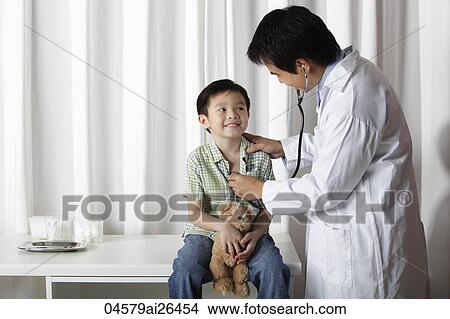 Doctor giving a little boy a check up View Large Photo Image Picture - Doctor giving a little boy a check up. Fotosearch