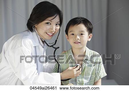 Stock Image - Doctor giving a young boy a check up. Fotosearch