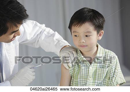 Doctor giving young boy a injection View Large Photo Image Stock Photography - Doctor giving young boy a injection. Fotosearch