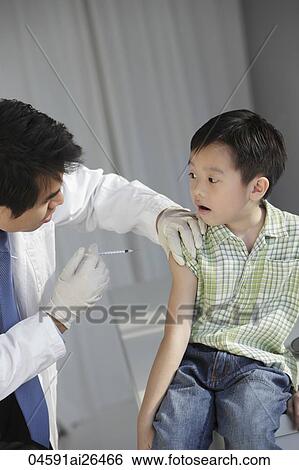 Doctor giving young boy an injection. View Large Photo Image Stock Photograph - Doctor giving young boy an injection.. Fotosearch