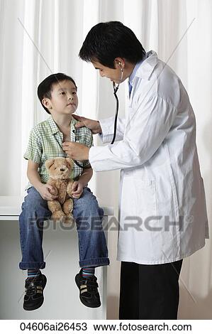 Doctor listening to young boy's heart View Large Photo Image Stock Image - Doctor listening to young boy's heart. Fotosearch