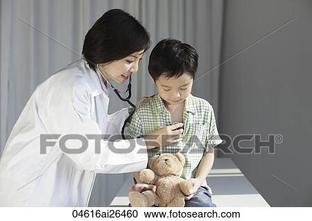 Doctor listening to young boy's heart. View Large Photo Image Stock Image - Doctor listening to young boy's heart.. Fotosearch