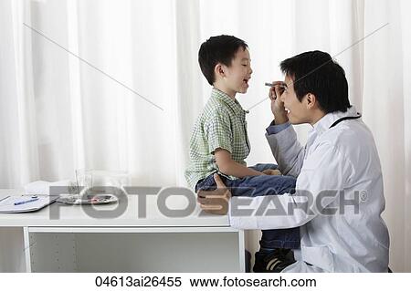 Doctor looking at young boy's mouth View Large Photo Image Stock Photography - Doctor looking at young boy's mouth. Fotosearch