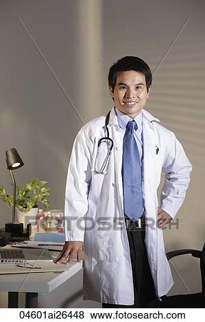 Doctor standing in office smiling View Large Photo Image Stock Photo - Doctor standing in office smiling. Fotosearch