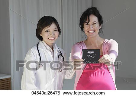 Female doctor with pregnant woman holding sonogram View Large Photo Image Stock Photography - Female doctor with pregnant woman holding sonogram. Fotosearch