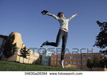 Happy Asian woman jumping in air. View Large Photo Image Picture - Happy Asian woman jumping in air.. Fotosearch
