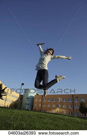 Stock Image - Happy Asian woman jumping in air. Fotosearch