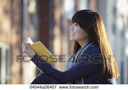 Stock Photo - Profile of Asian woman reading book. Fotosearch