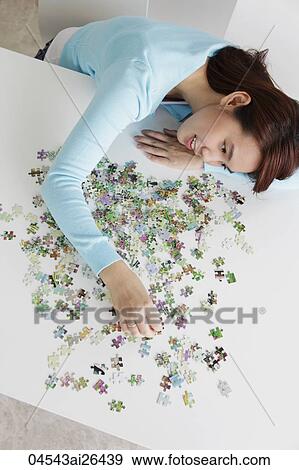 top view of young woman putting puzzle together View Large Photo Image Stock Photo - top view of young woman putting puzzle together. Fotosearch