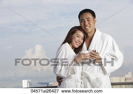 Young couple in robes hugging and smiling View Large Photo Image Stock Photo - Young couple in robes hugging and smiling. Fotosearch