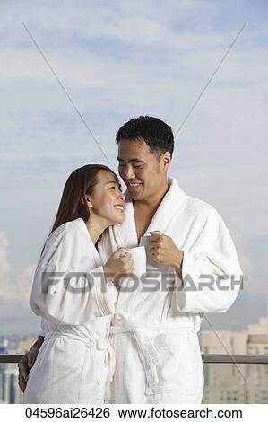 Young couple in robes smiling at each other View Large Photo Image Stock Photograph - Young couple in robes smiling at each other. Fotosearch