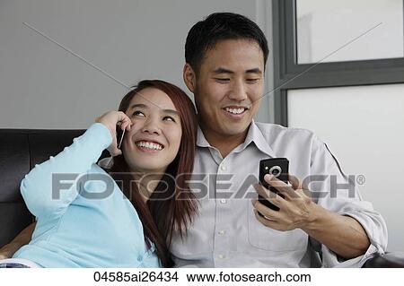 Young couple talking on their phones View Large Photo Image Picture - Young couple talking on their phones. Fotosearch