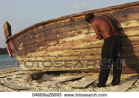 Asian man fixing boat on the beach View Large Photo Image Stock Image - Asian man fixing boat on the beach. Fotosearch