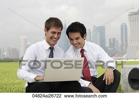 Chinese and Caucasian man looking at laptop out side View Large Photo Image Stock Image - Chinese and Caucasian man looking at laptop out side. Fotosearch