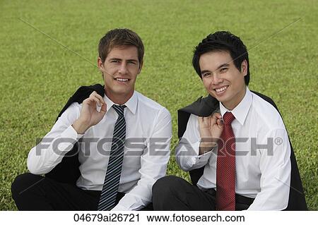Chinese and Caucasian man sitting on grass with coats off View Large Photo Image Stock Image - Chinese and Caucasian man sitting on grass with coats off. Fotosearch
