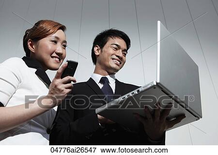 Chinese couple looking at laptop and smiling View Large Photo Image Stock Photo - Chinese couple looking at laptop and smiling. Fotosearch