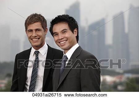 Stock Photography - Chinese man and Caucasian man standing in front of buildings. Fotosearch