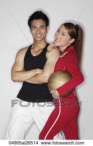 Chinese man and woman holding a basketball and smiling View Large Photo Image Picture - Chinese man and woman holding a basketball and smiling. Fotosearch