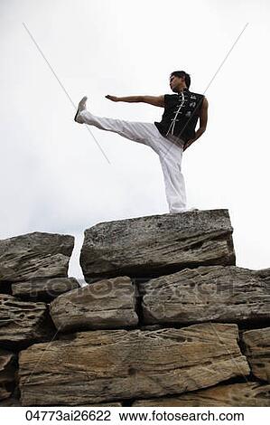 Chinese man doing martial arts on top of large rocks View Large Photo Image Stock Image - Chinese man doing martial arts on top of large rocks. Fotosearch