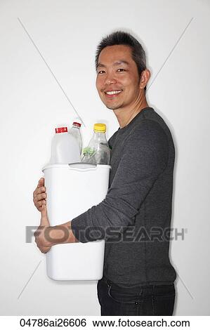 Stock Photograph - Chinese man holding bucket of bottles to recycle. Fotosearch