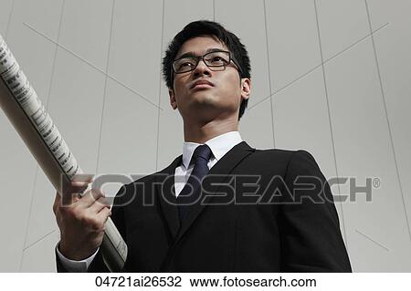 Stock Image - Chinese man holding building plans. Fotosearch