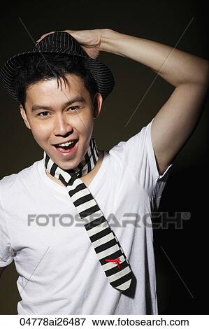 Stock Photo - Chinese man holding his hat and smiling. Fotosearch