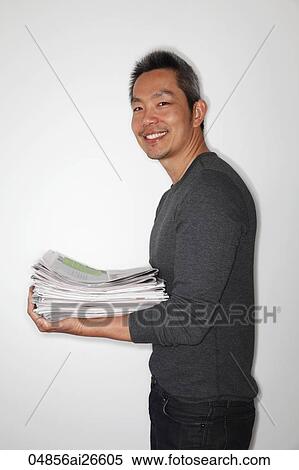 Chinese man holding newspapers ready to recycle View Large Photo Image Stock Photography - Chinese man holding newspapers ready to recycle. Fotosearch