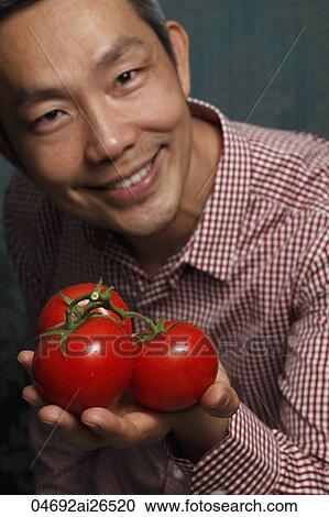 Chinese man holding red tomatoes View Large Photo Image Stock Image - Chinese man holding red tomatoes. Fotosearch