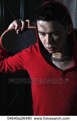 Chinese man holding skateboard behind his head. View Large Photo Image Stock Image - Chinese man holding skateboard behind his head.. Fotosearch