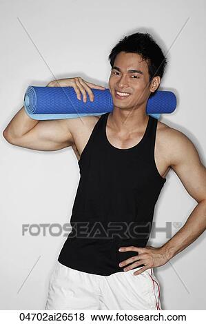 Chinese man holding yoga mat and smiling View Large Photo Image Stock Photo - Chinese man holding yoga mat and smiling. Fotosearch