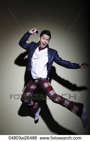 Chinese man jumping while holding a camera View Large Photo Image Stock Photograph - Chinese man jumping while holding a camera. Fotosearch