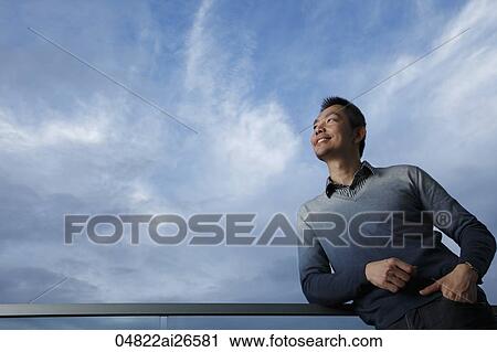 Chinese man leaning on railing and looking at blue sky View Large Photo Image Stock Image - Chinese man leaning on railing and looking at blue sky. Fotosearch