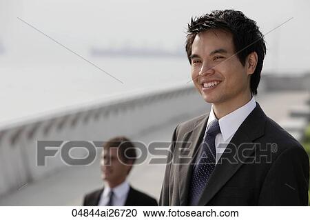 Stock Image - Chinese man looking at view and smiling. Fotosearch