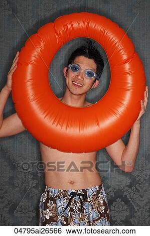 Chinese man looking through orange inner tube and smiling View Large Photo Image Stock Photograph - Chinese man looking through orange inner tube and smiling. Fotosearch