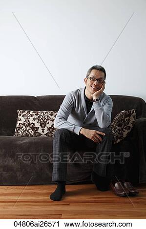 Chinese man relaxing at home on sofa View Large Photo Image Stock Image - Chinese man relaxing at home on sofa. Fotosearch