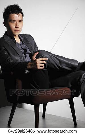 Stock Photography - Chinese man sitting in chair. Fotosearch