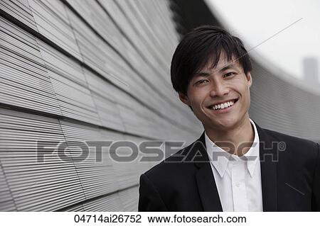 Chinese man smiling at camera in front of building View Large Photo Image Stock Image - Chinese man smiling at camera in front of building. Fotosearch