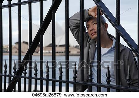 Chinese man standing at gate and looking up View Large Photo Image Stock Photo - Chinese man standing at gate and looking up. Fotosearch