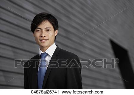 Chinese man wearing a suit smiling in front of building View Large Photo Image Stock Image - Chinese man wearing a suit smiling in front of building. Fotosearch