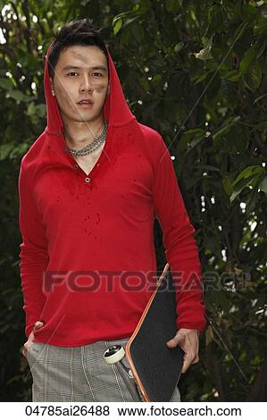 Chinese man wearing red hooded sweatshirt and holding skateboard View Large Photo Image Stock Photo - Chinese man wearing red hooded sweatshirt and holding skateboard. Fotosearch