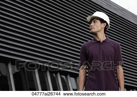 Chinese man with construction hat in front of building View Large Photo Image Picture - Chinese man with construction hat in front of building. Fotosearch