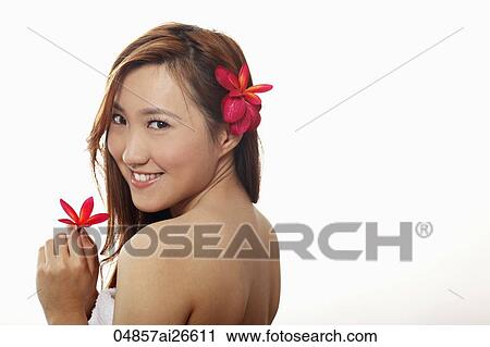 Chinese woman holding a flower and with flower behind her ear View Large Photo Image Stock Image - Chinese woman holding a flower and with flower behind her ear. Fotosearch