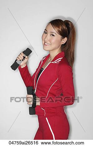 Stock Photograph - Chinese woman holding weights and working out. Fotosearch