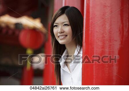 Chinese woman looking out from behind red pillars View Large Photo Image Stock Image - Chinese woman looking out from behind red pillars. Fotosearch