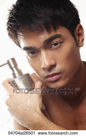 Stock Image - Head shot of Chinese man holding bottle. Fotosearch