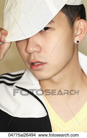 Picture - Head shot of Chinese man holding cap. Fotosearch