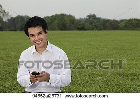 man in white shirt texting on phone and smiling View Large Photo Image Stock Image - man in white shirt texting on phone and smiling. Fotosearch