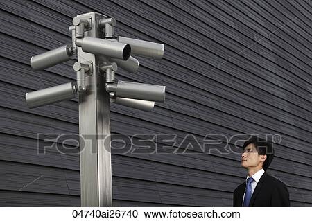 Stock Image - Man looking at surveillance cameras. Fotosearch