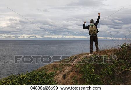 Man wearing back pack with arms up stretched into the air View Large Photo Image Stock Photo - Man wearing back pack with arms up stretched into the air. Fotosearch