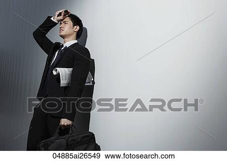 Stock Photo - Man wearing business suit wiping his brow and frowning. Fotosearch